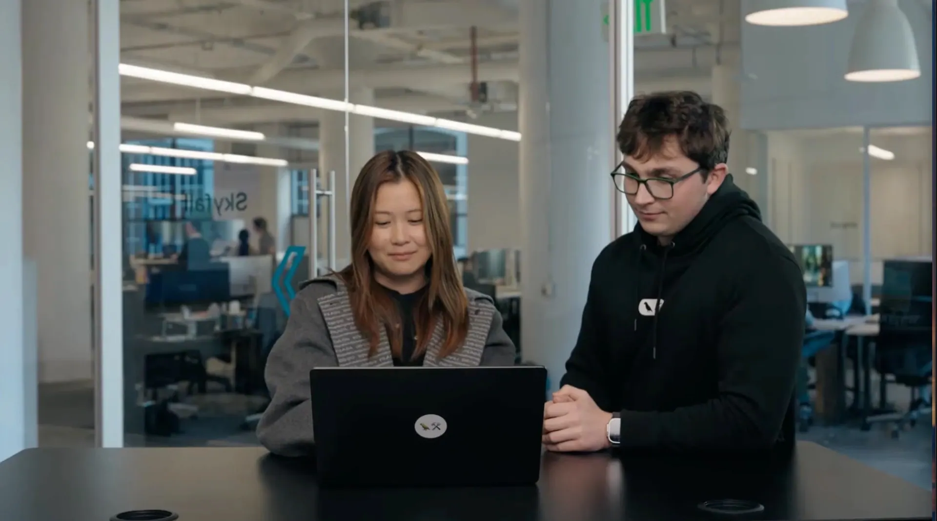 Two LangChain team members looking at a laptop in the office